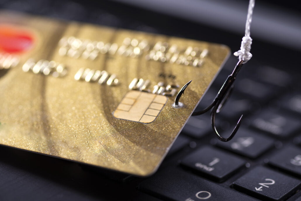 internet fraud using computer technology stealing money internet stealing credit card data hook hooked credit card laptop keyboard background