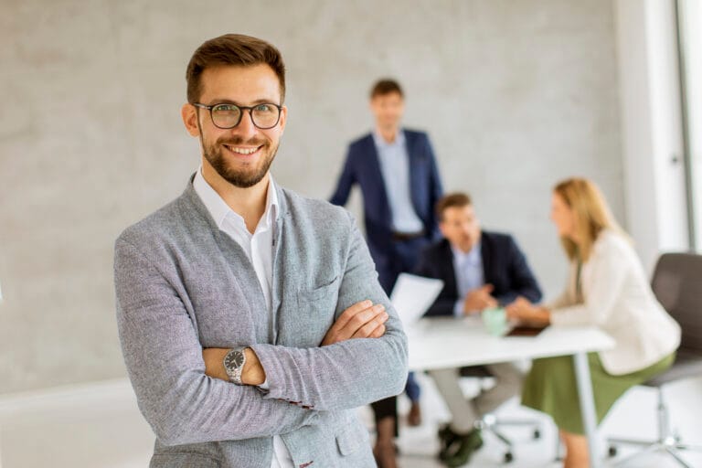 beau jeune homme d affaires debout confiant dans le bureau en face de son equipe